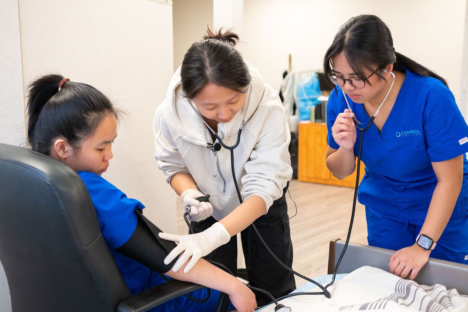 Nursing students practise taking a blood pressure reading.