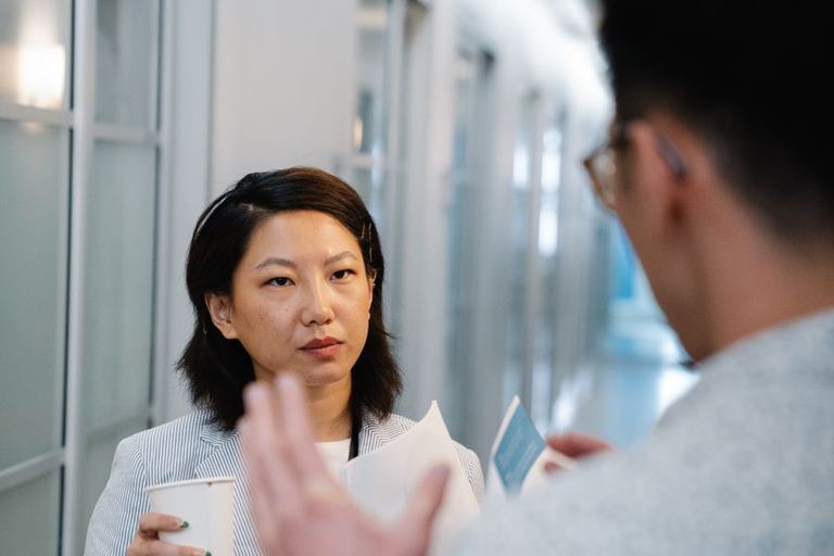 A woman explains a point to a listening colleague.
