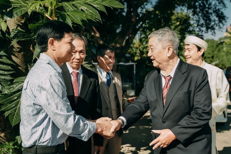 Club members shake hands at an outdoor gathering.